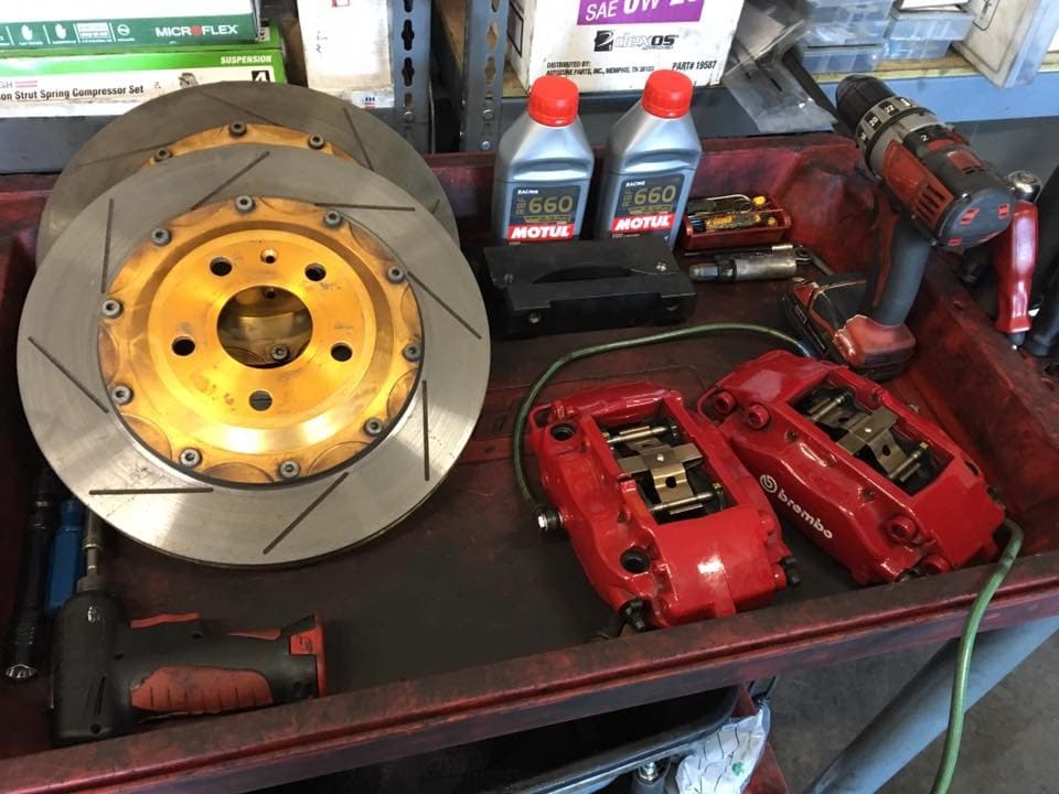 A brake rotor and calipers on the bench in our shop